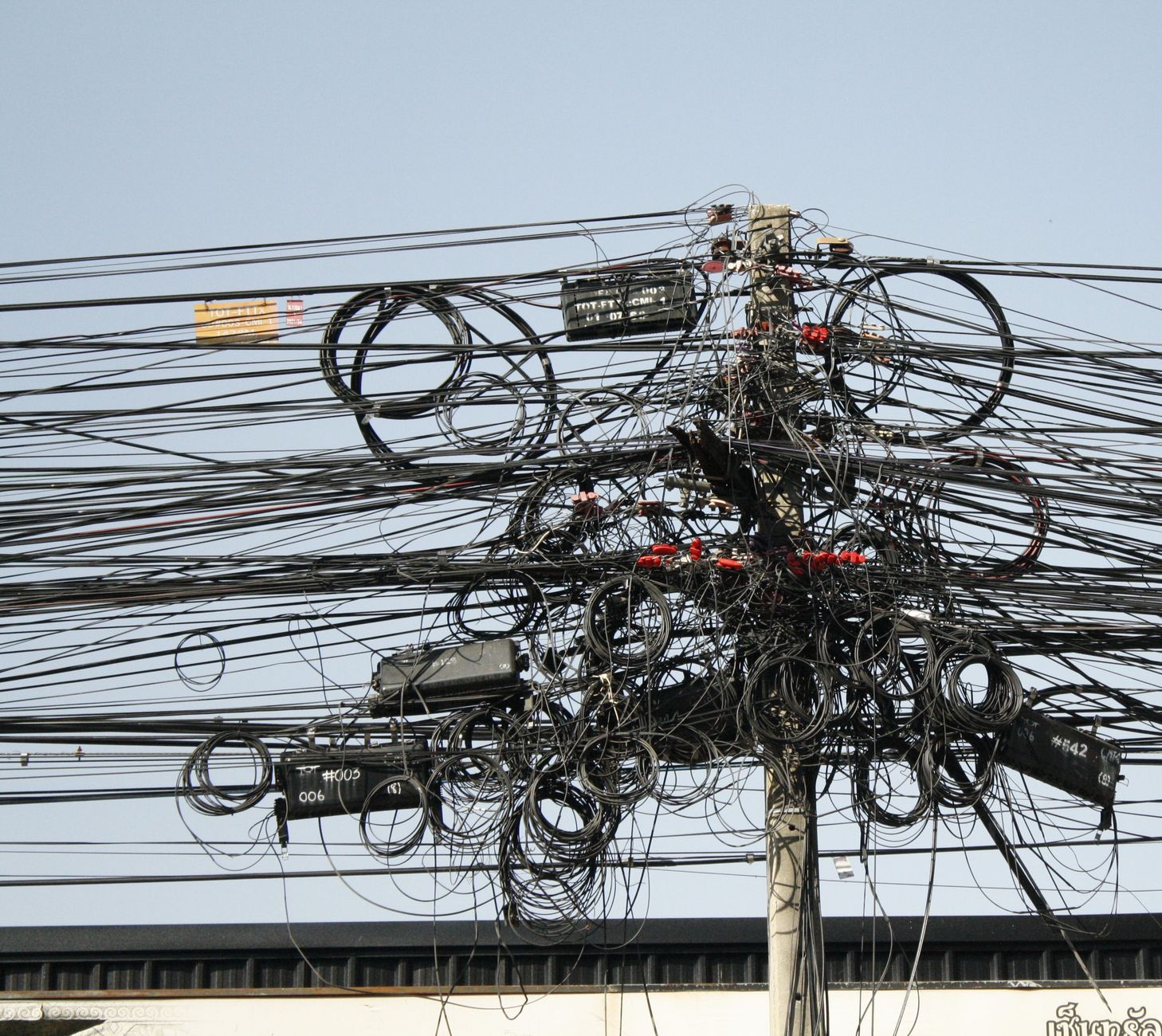 Dense power and telecom cabling on utility poles in Southeast Asia, the existing infrastructure Frontier fibre routes run alongside